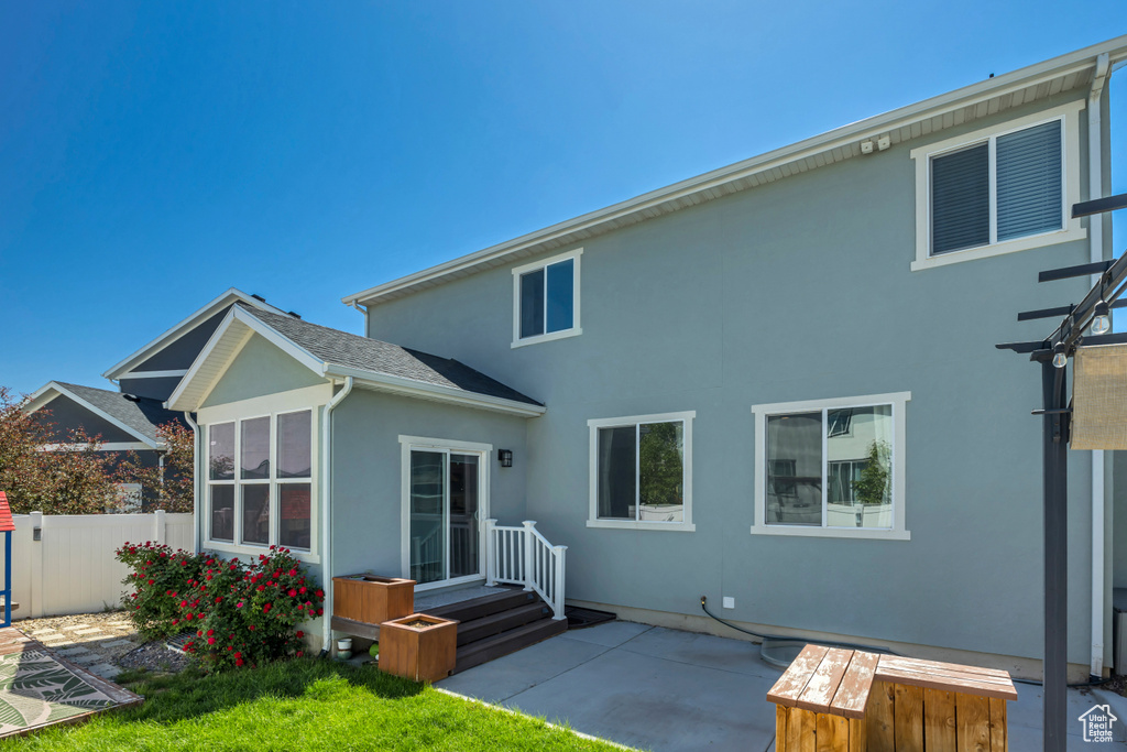 Rear view of house with stucco siding and a patio area
