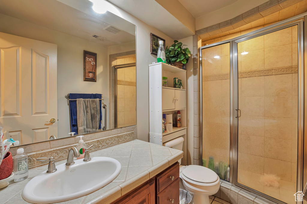Bathroom with a shower stall, toilet, and vanity