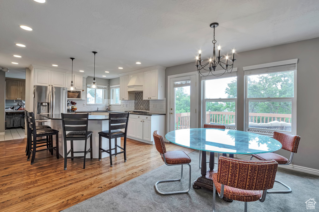 Dining area with light wood-style flooring, a chandelier, and recessed lighting