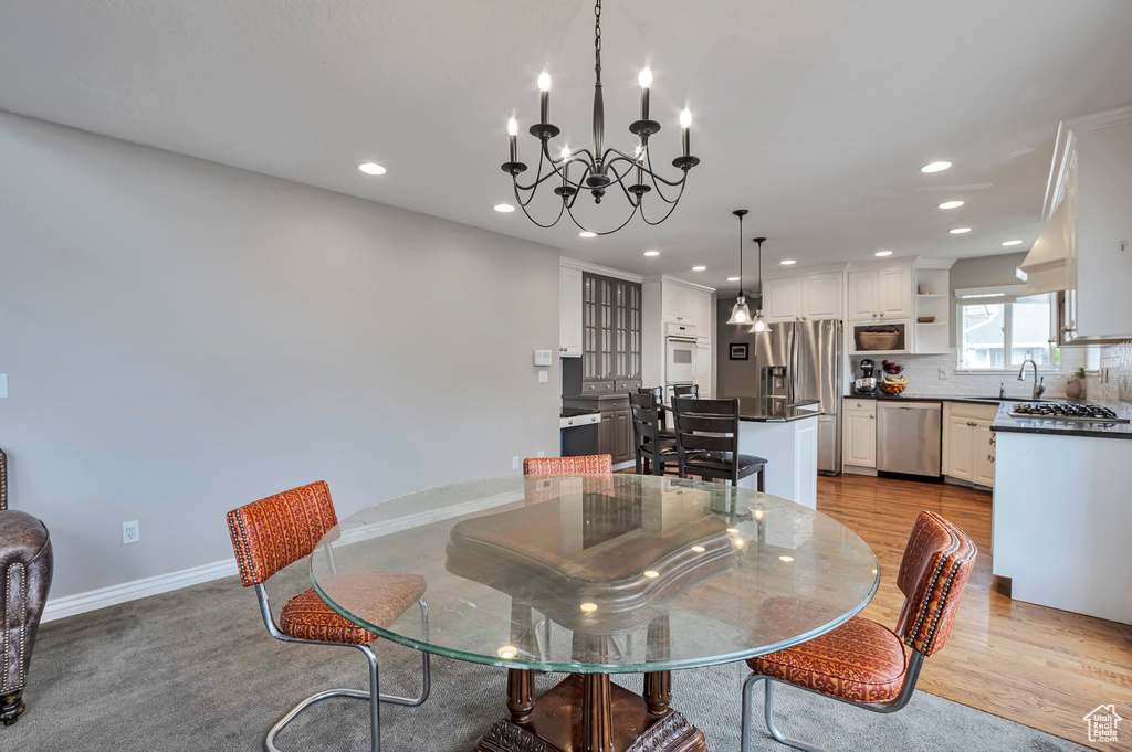 Dining space featuring a chandelier, recessed lighting, light wood-style flooring, and baseboards