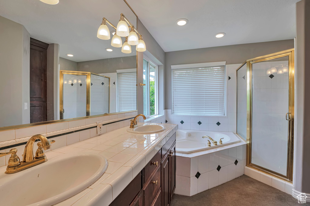 Bathroom with a stall shower, a bath, double vanity, and recessed lighting
