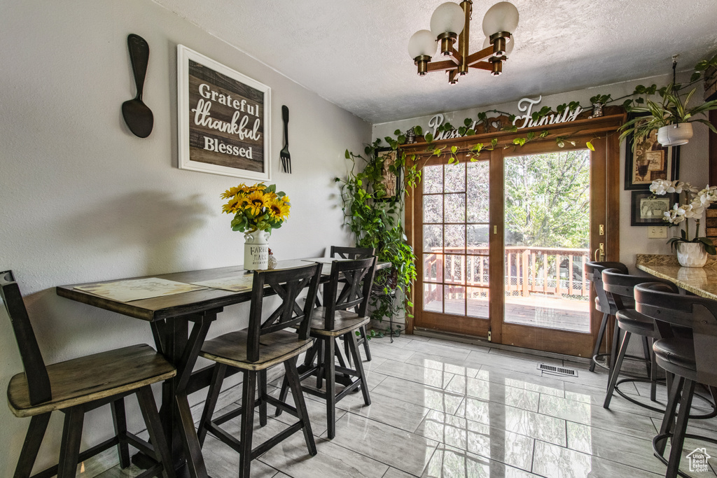 Dining area with a chandelier and a textured ceiling