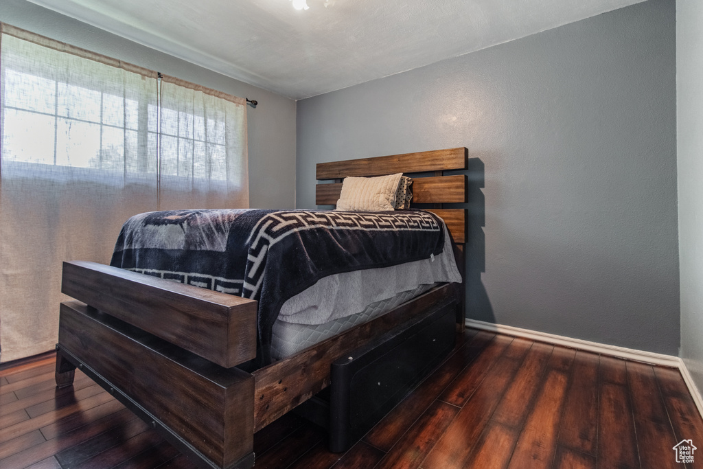 Bedroom with hardwood / wood-style floors and baseboards