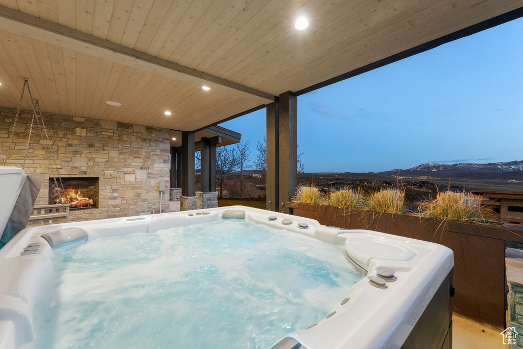 Exterior space featuring an outdoor stone fireplace and a hot tub
