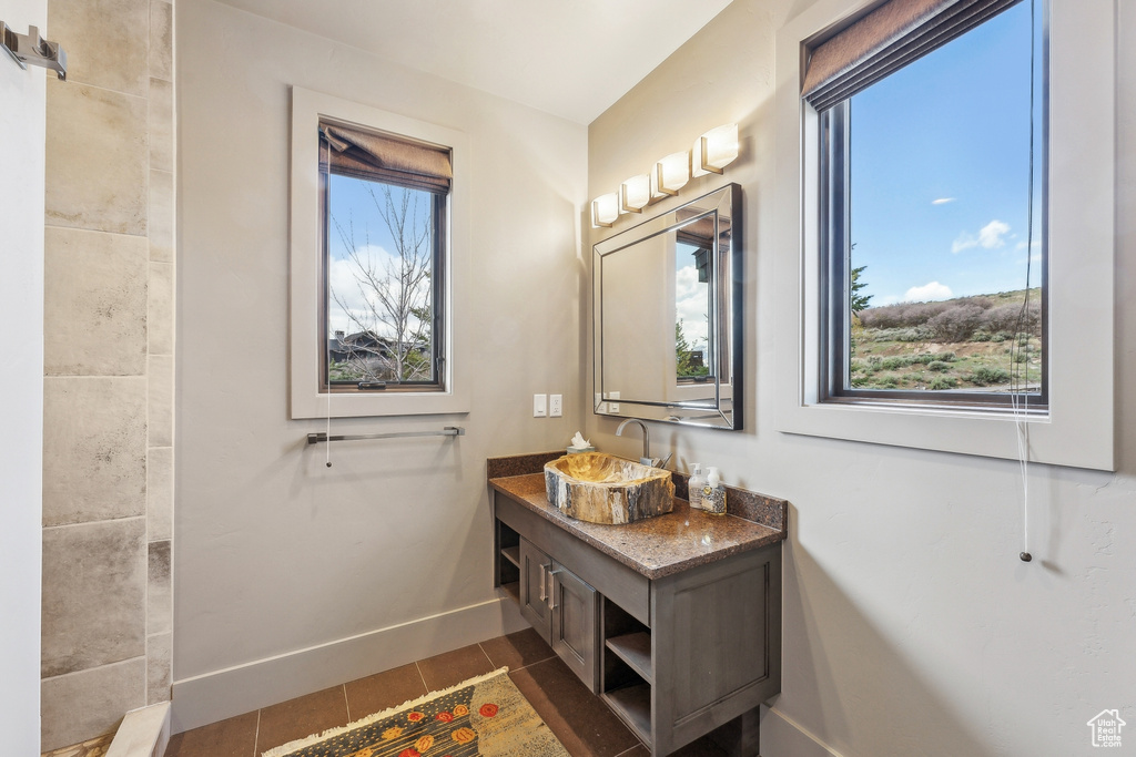 Bathroom with baseboards, vanity, and tile patterned flooring