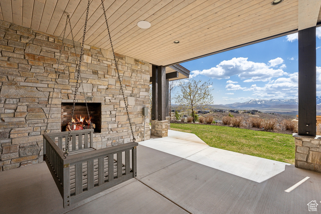 View of patio featuring a mountain view and an outdoor stone fireplace