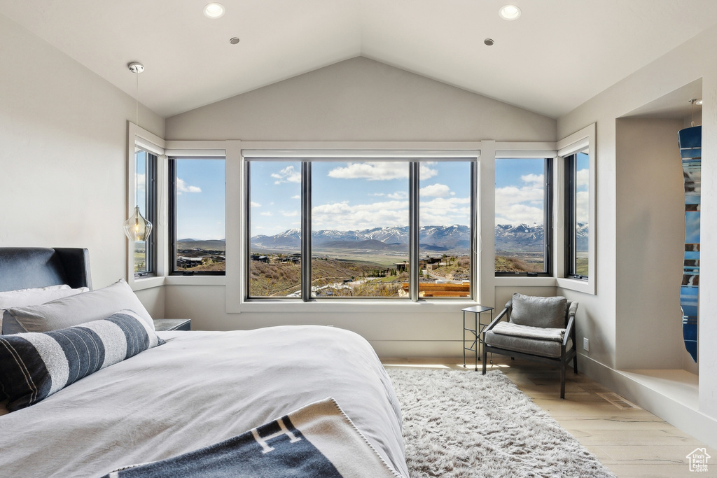 Bedroom featuring vaulted ceiling, recessed lighting, wood finished floors, and multiple windows