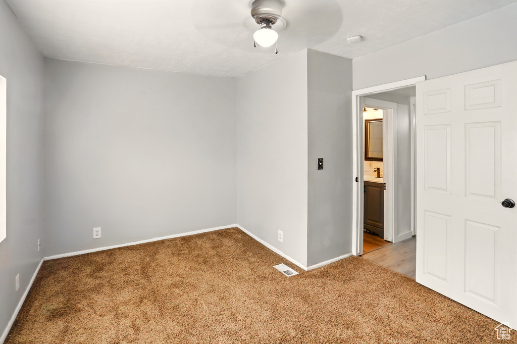 Unfurnished room featuring light carpet, ceiling fan, and baseboards