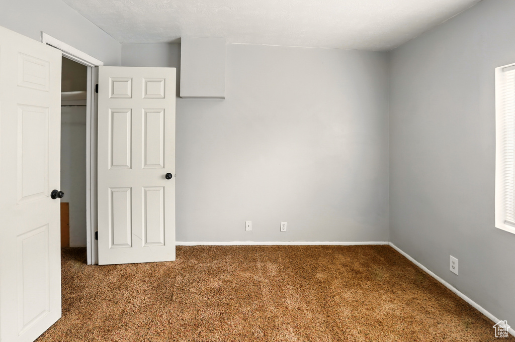 Unfurnished bedroom with carpet floors and baseboards