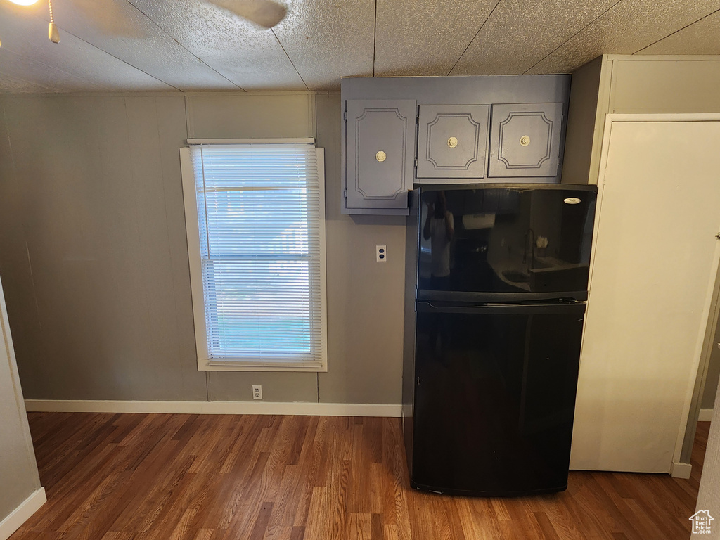 Kitchen featuring freestanding refrigerator, healthy amount of natural light, wood finished floors, and baseboards