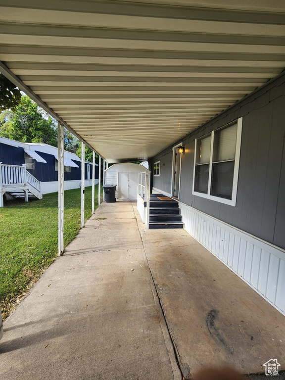 View of patio / terrace featuring an outdoor structure and a carport