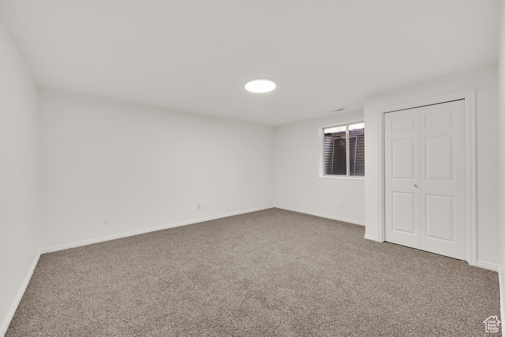 Unfurnished bedroom with carpet floors, baseboards, and a closet