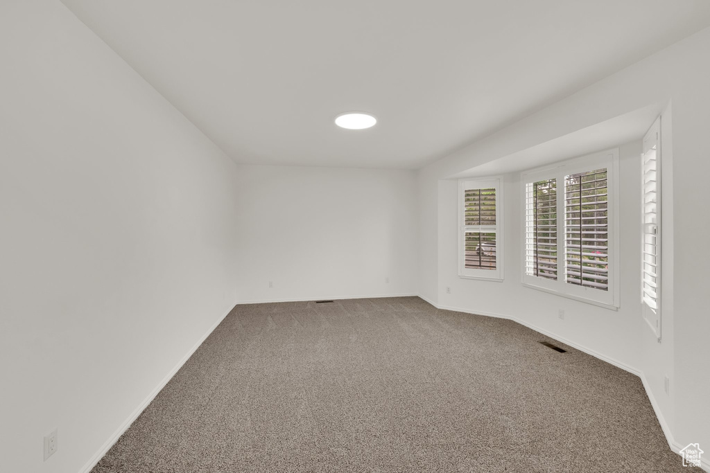 Empty room with carpet floors and baseboards