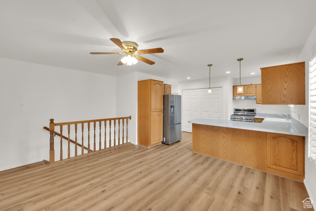 Kitchen featuring stainless steel appliances, light wood finished floors, recessed lighting, a peninsula, and a ceiling fan