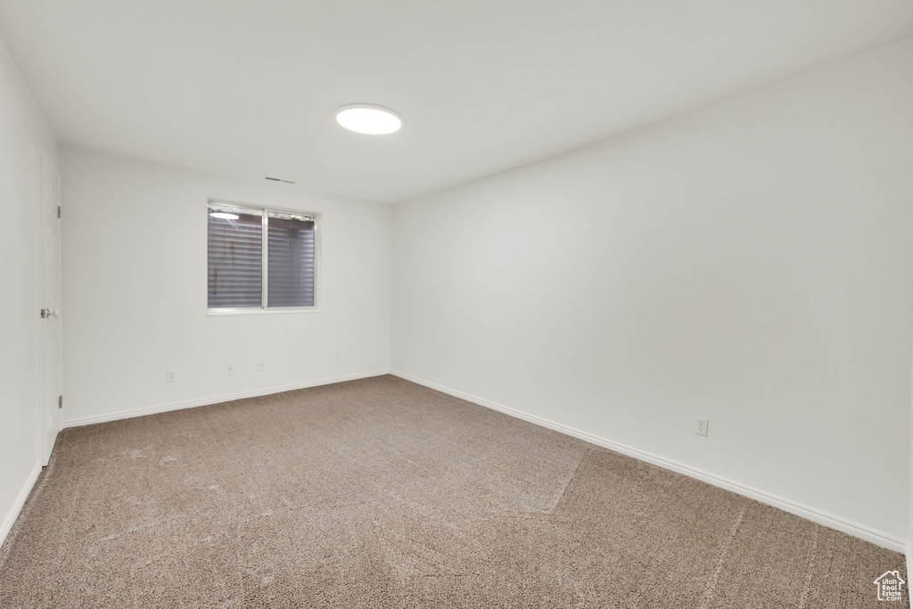 Carpeted empty room with baseboards