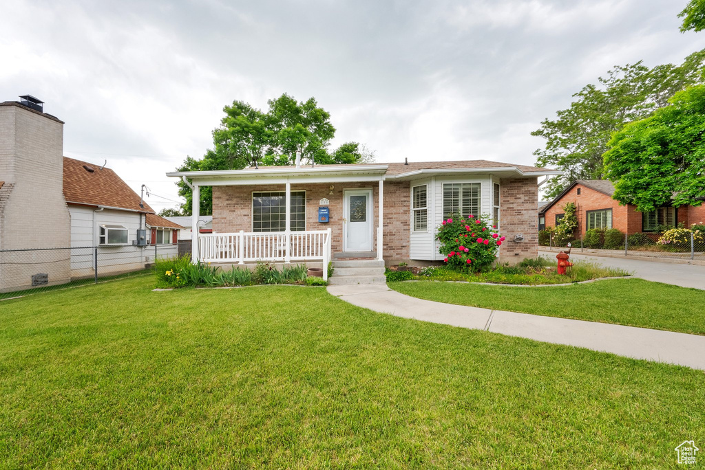 View of front of home with a porch and brick siding
