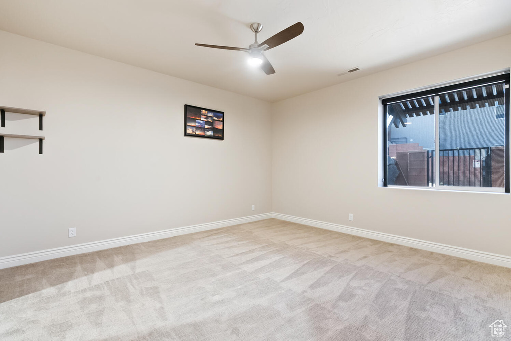 Unfurnished room featuring a ceiling fan and carpet