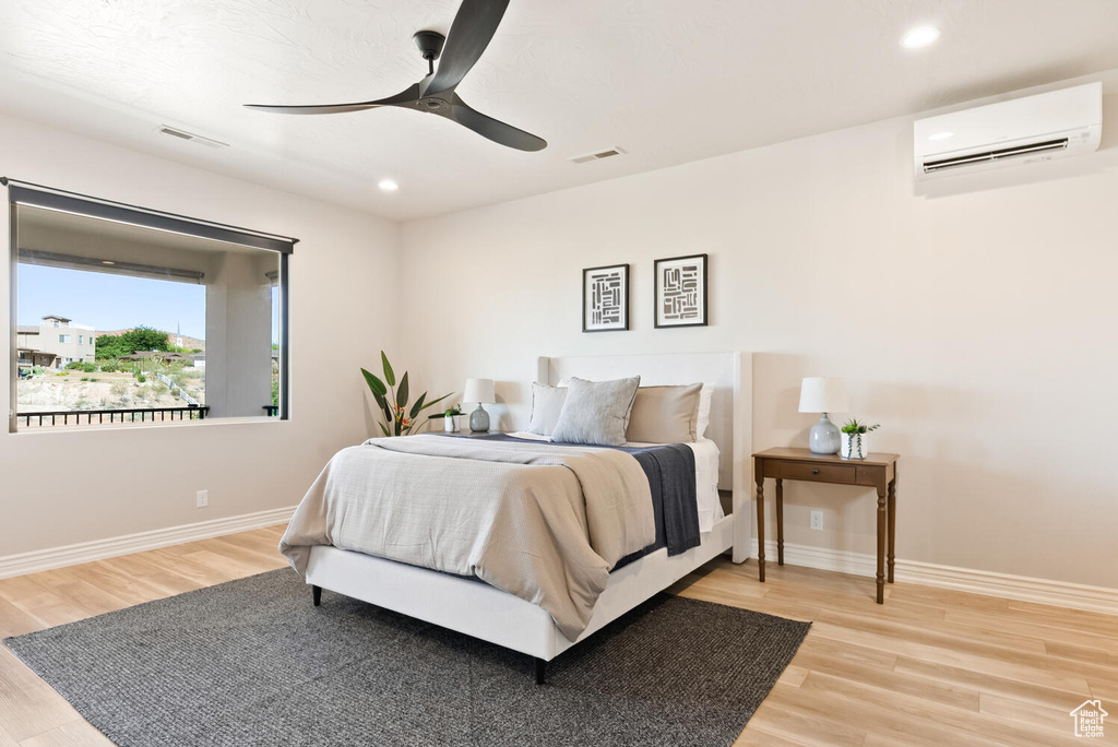 Bedroom featuring an AC wall unit, wood finished floors, recessed lighting, and ceiling fan