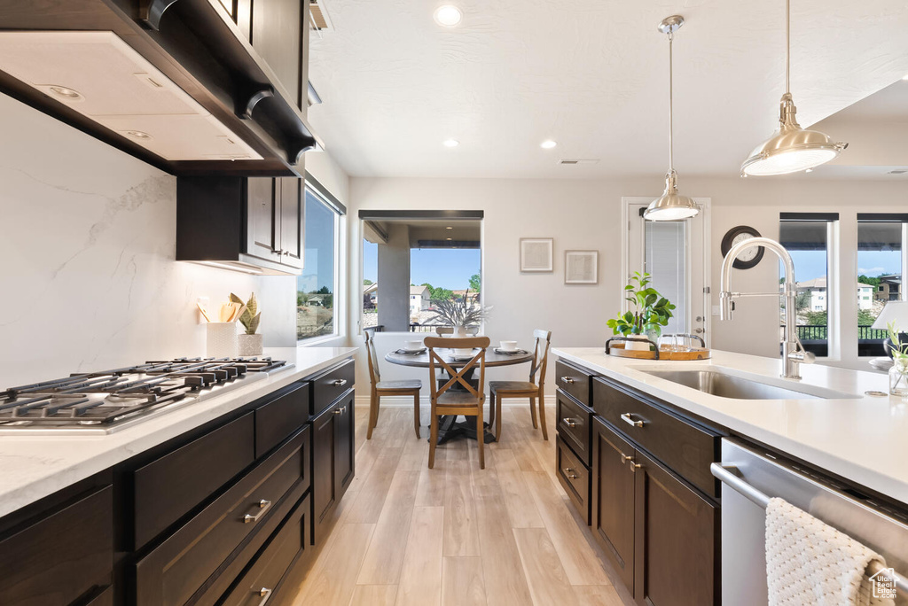 Kitchen with appliances with stainless steel finishes, a sink, plenty of natural light, under cabinet range hood, and recessed lighting