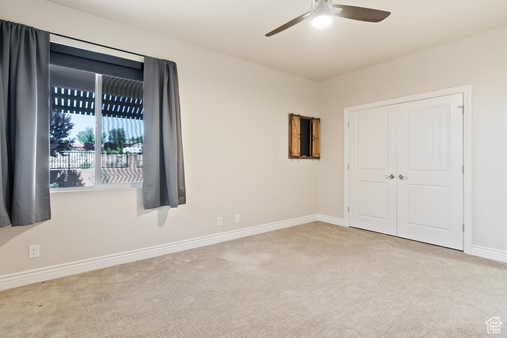 Unfurnished bedroom featuring carpet, baseboards, a ceiling fan, and a closet