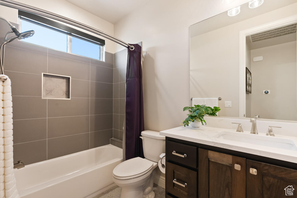 Full bathroom with shower / bath combination with curtain, vanity, and toilet