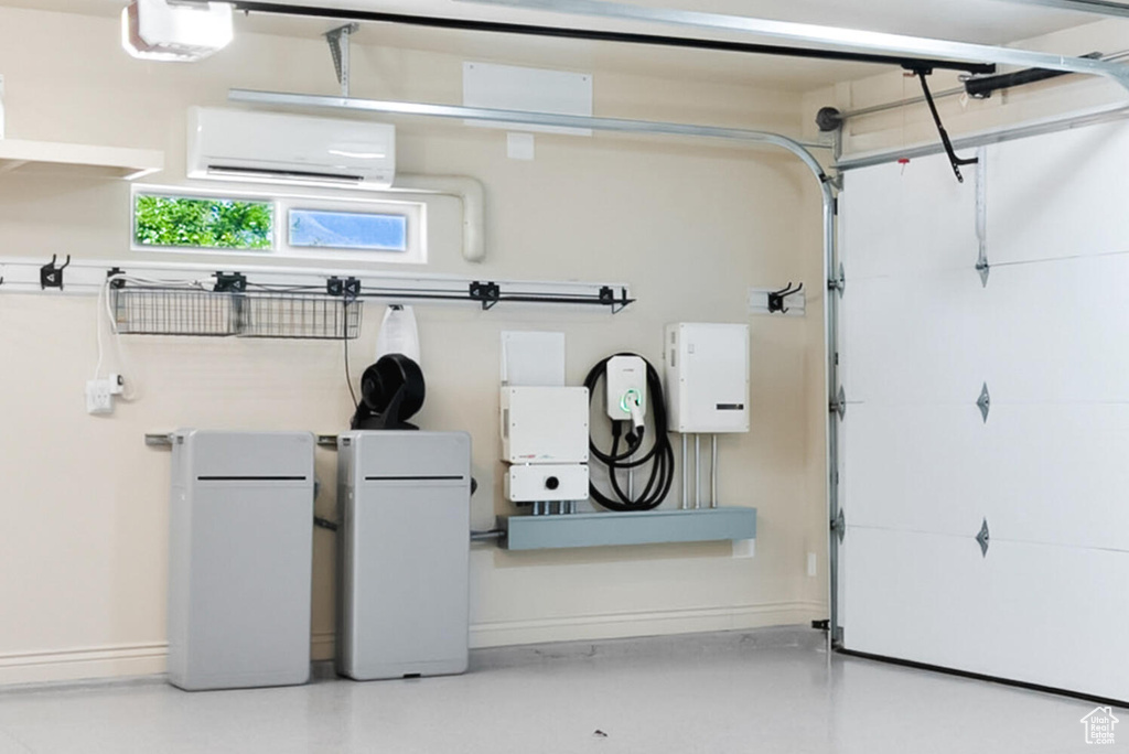 Garage with a wall mounted AC and baseboards