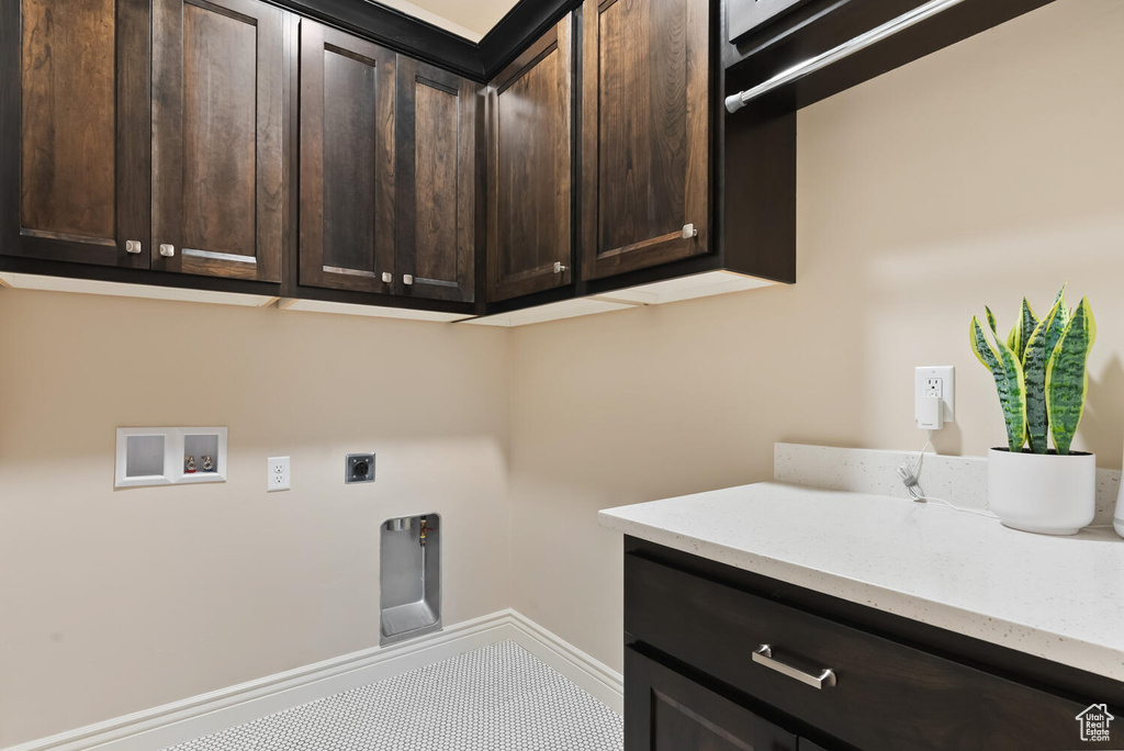 Laundry area with washer hookup, electric dryer hookup, cabinet space, and baseboards