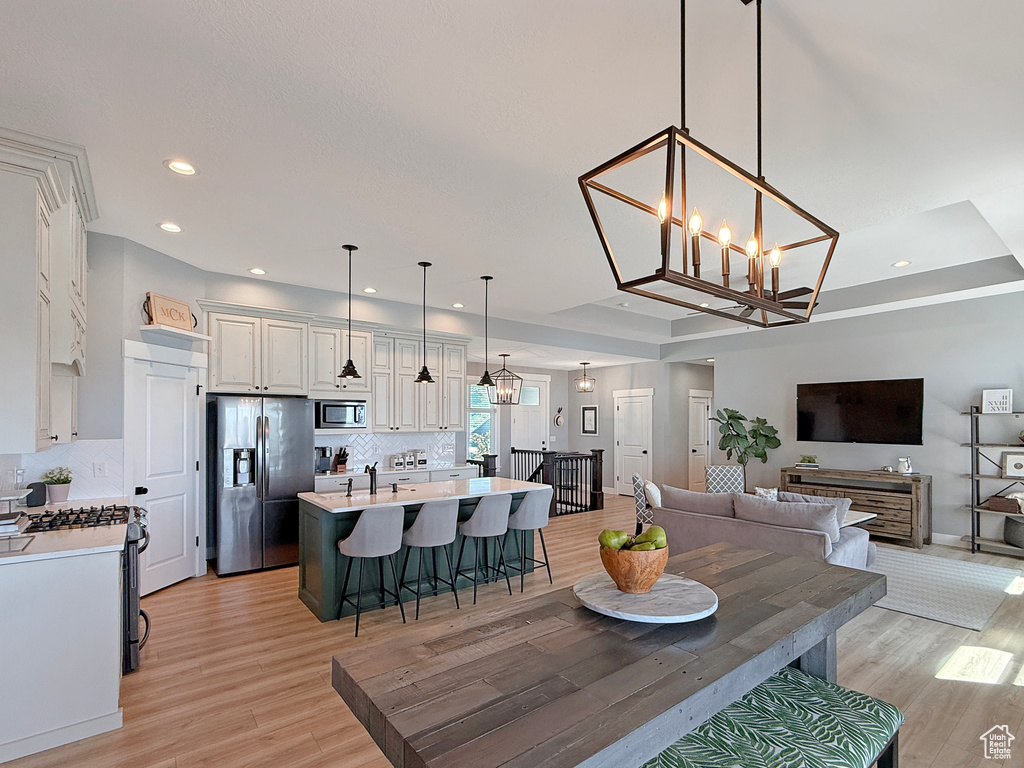 Dining room featuring light wood-style flooring, a chandelier, recessed lighting, and baseboards