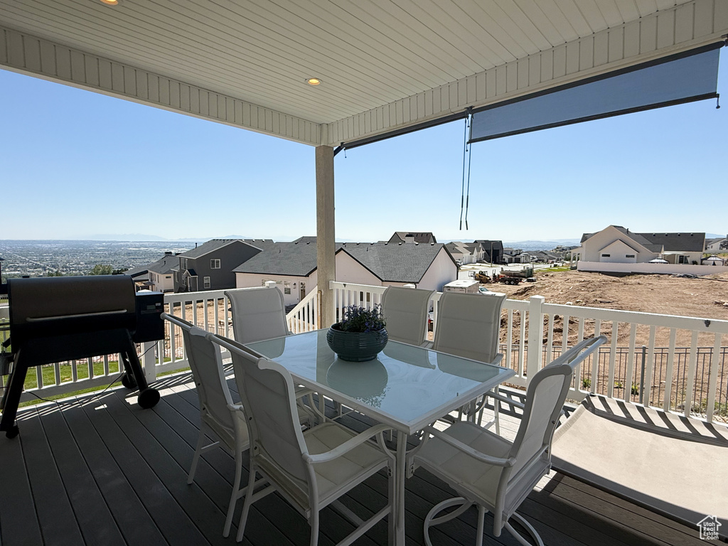 Wooden terrace featuring outdoor dining space and a residential view