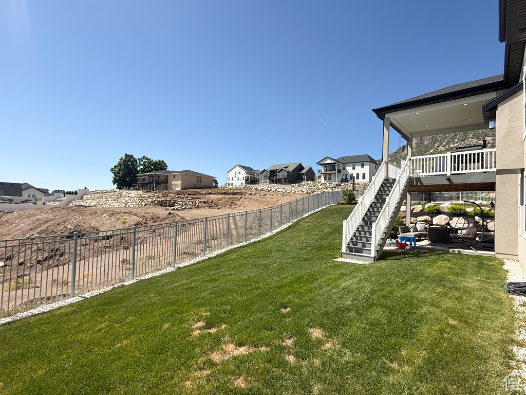 View of yard featuring a residential view, stairs, and a patio