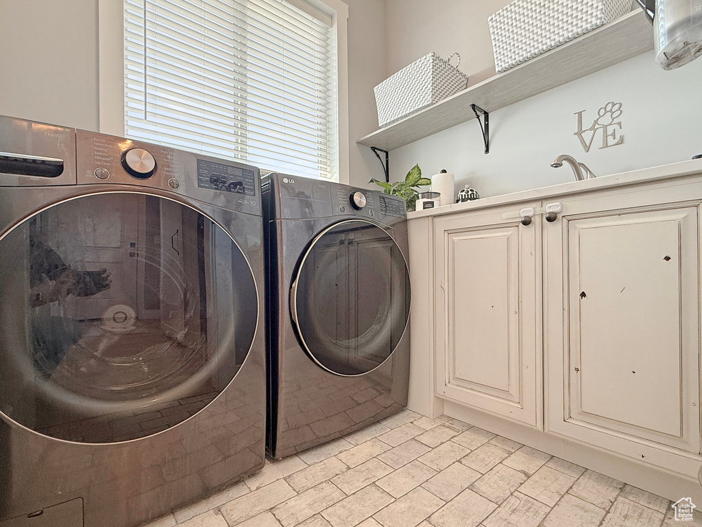 Laundry area featuring separate washer and dryer and cabinet space