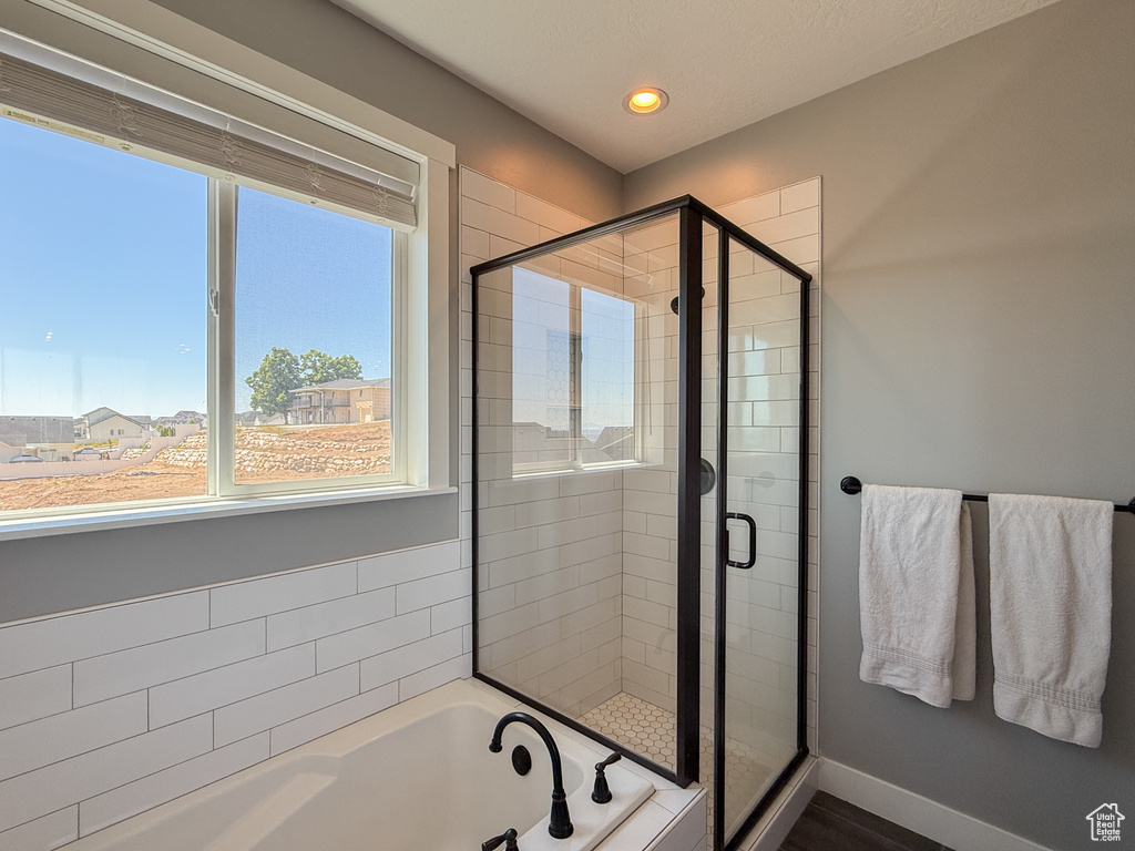 Bathroom featuring a garden tub, a stall shower, recessed lighting, and baseboards