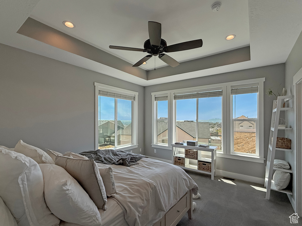 Bedroom with a raised ceiling, carpet, baseboards, recessed lighting, and ceiling fan