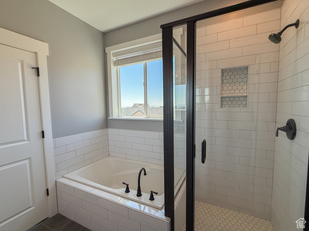 Bathroom with a shower stall and a bath