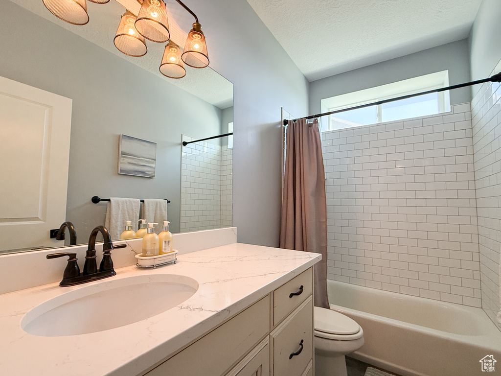 Full bathroom with vanity, toilet, and shower / bath combo with shower curtain