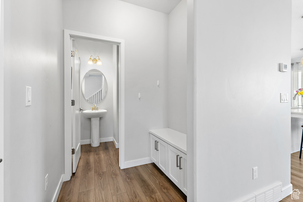 Corridor with dark wood-type flooring and baseboards