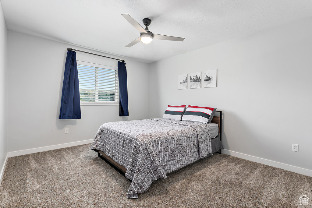Carpeted bedroom with baseboards and a ceiling fan
