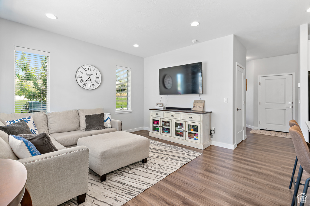 Living room with wood finished floors, baseboards, and recessed lighting