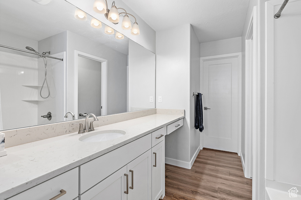 Bathroom featuring vanity, wood finished floors, and baseboards
