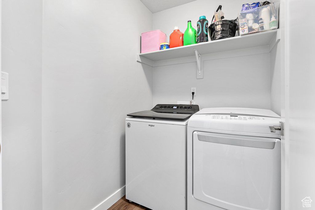 Laundry area with independent washer and dryer, baseboards, and wood finished floors