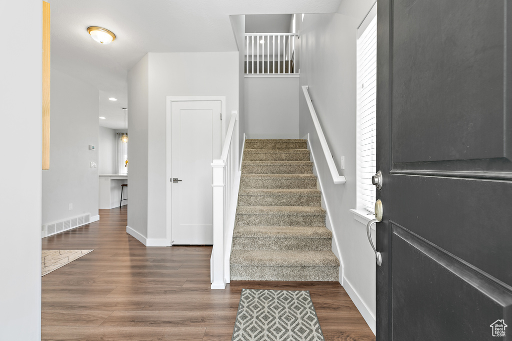 Stairs featuring wood finished floors, baseboards, and recessed lighting