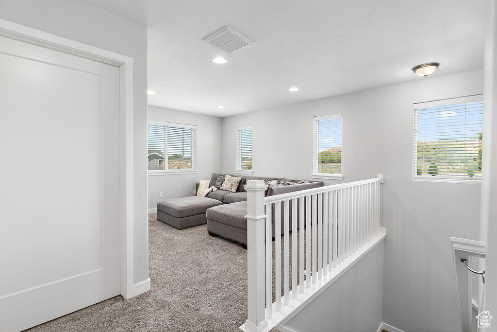 Hall with an upstairs landing, carpet floors, recessed lighting, and baseboards