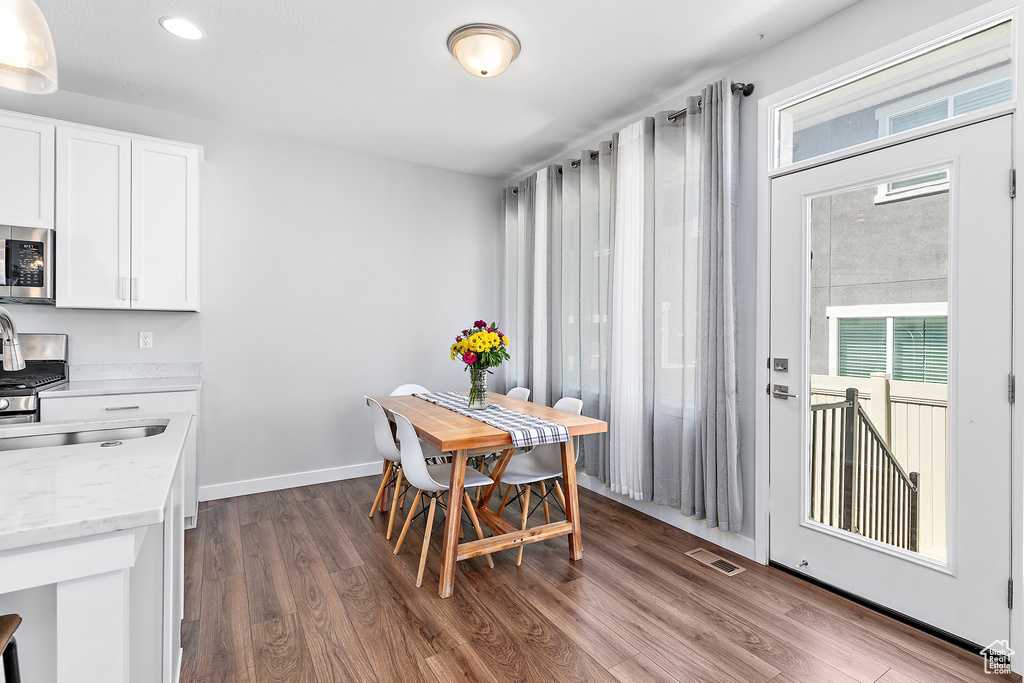 Dining space featuring healthy amount of natural light, dark wood-style floors, baseboards, and recessed lighting