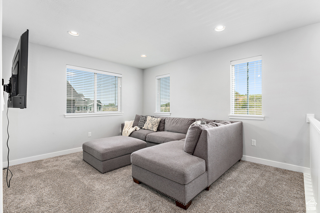 Living room with healthy amount of natural light, baseboards, recessed lighting, and carpet floors