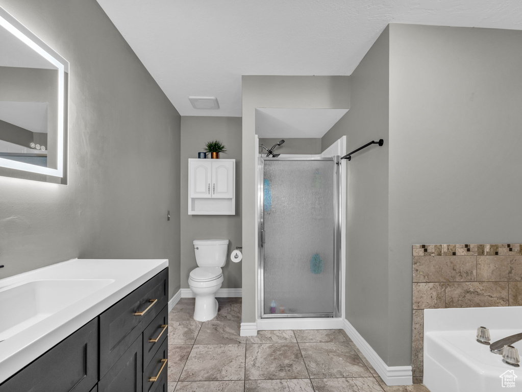 Bathroom with vanity, a stall shower, toilet, and a bath