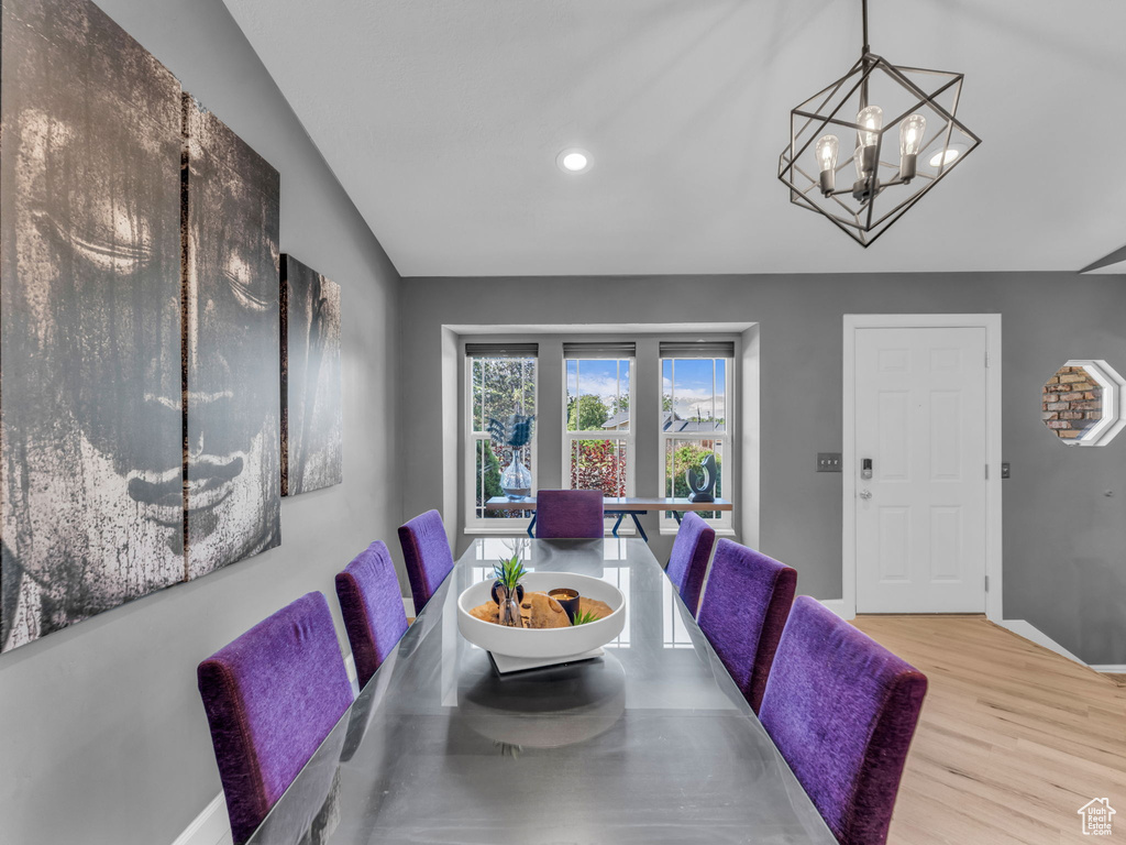 Dining space featuring a chandelier, wood finished floors, vaulted ceiling, baseboards, and recessed lighting