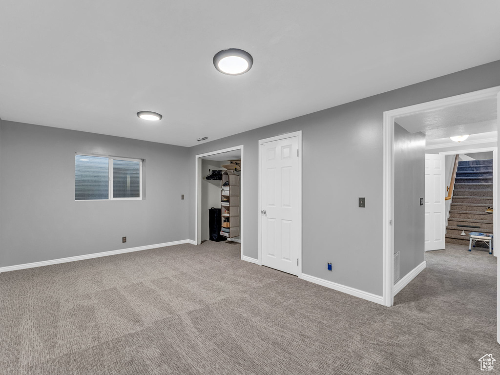 Finished basement with carpet, stairway, and baseboards