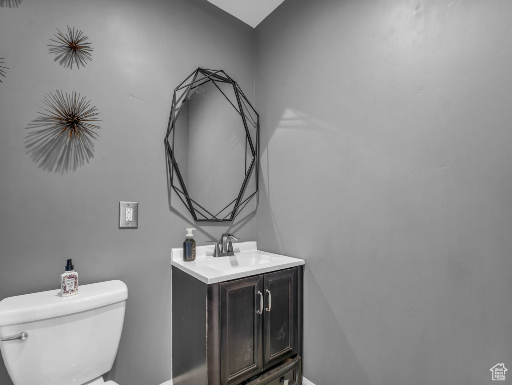 Bathroom with toilet, baseboards, and vanity
