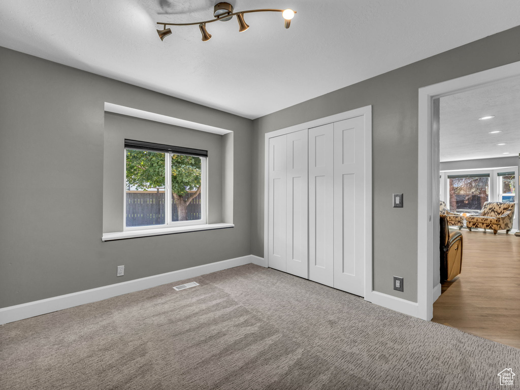 Unfurnished bedroom with baseboards, a closet, recessed lighting, and carpet floors