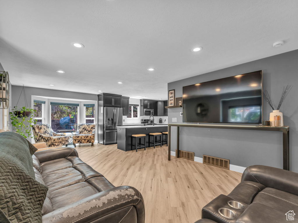 Living area featuring light wood-style flooring, recessed lighting, and baseboards